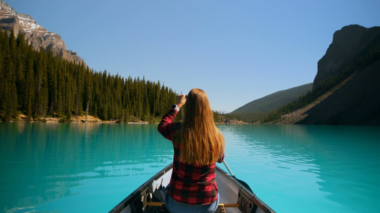 mujer remando un barco en el río en el campo 4k