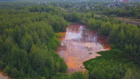 vía fluvial contaminada rodeada de bosque y una ciudad