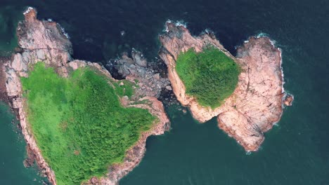 cape d'aguilar, hong kong: dynamic drone flyover that travels over coastline and between two small islands