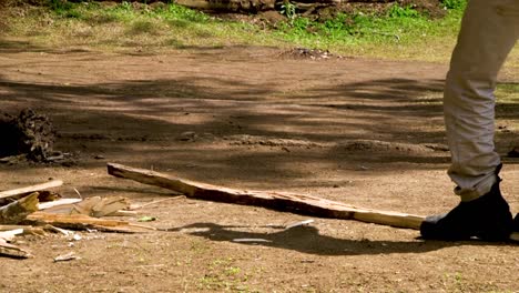 young boy chopping firewood with axe