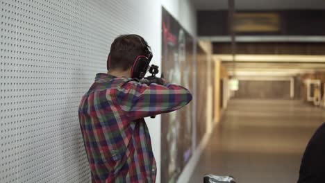 Man-practicing-using-a-rifle-at-shooting-range-in-headphones