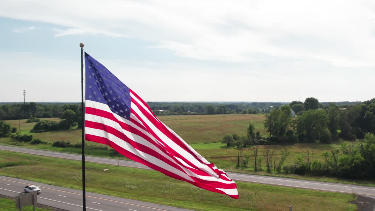 Huge American flag dancing in the sun, smooth 4K aerial