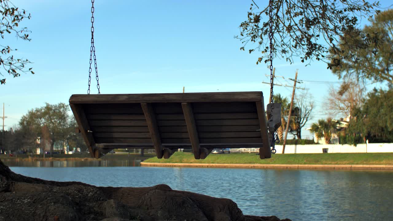 banco de columpio en el árbol cerca del agua exterior del cielo azul durante el día