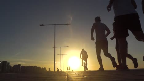 gente haciendo ejercicio con una puesta de sol de fondo