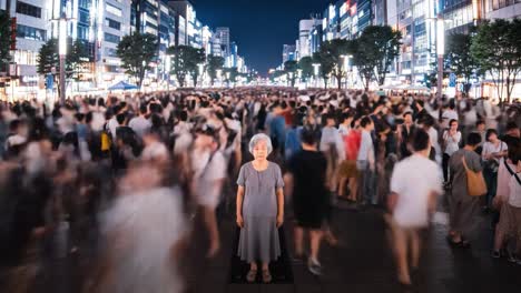 a bustling street in tokyo filled with a sea of people moving in various directions.