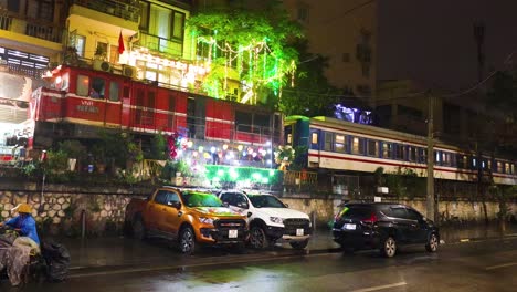 nighttime train passing by vibrant hanoi street