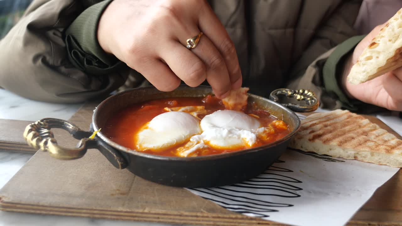 mujer comiendo shakshuka con pan
