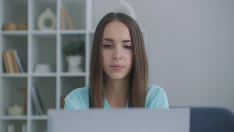 Focused-business-woman-entrepreneur-typing-on-laptop-doing-research.-Young-female-professional-using-computer-sitting-at-home-office-desk.-Busy-worker-freelancer-working-on-modern-tech-notebook-device