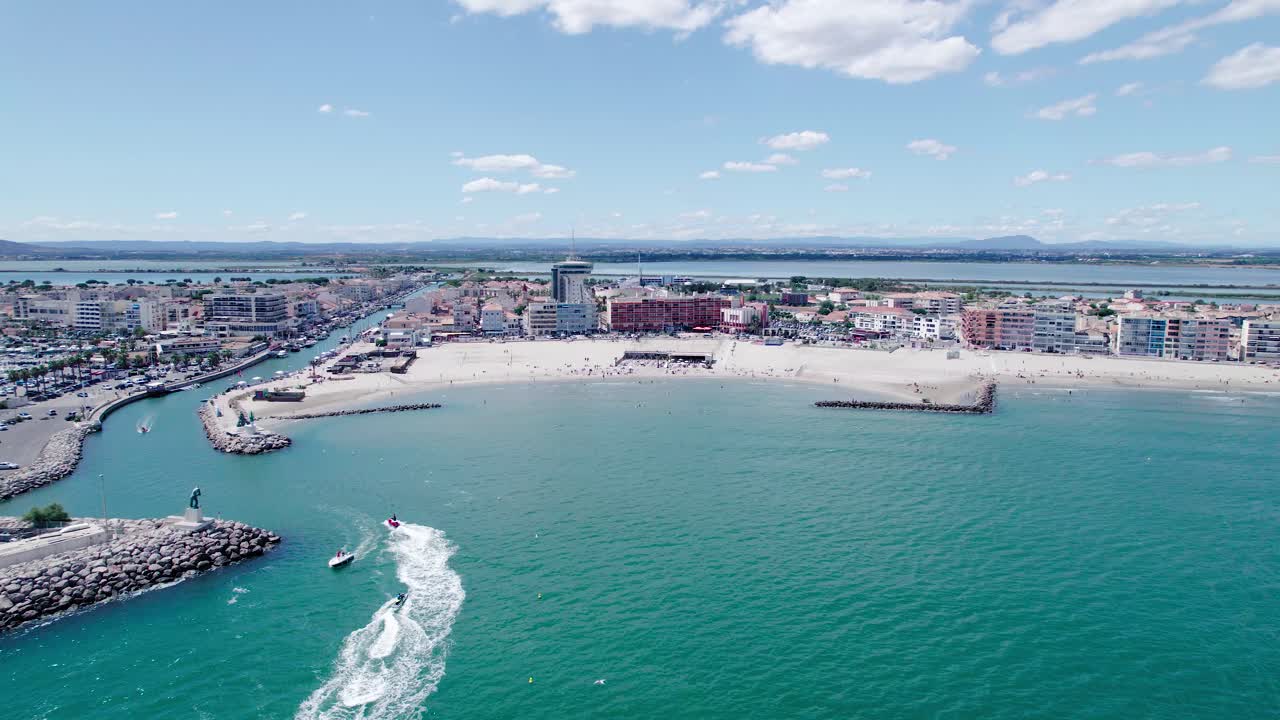 Carrellata aerea verso Palavas-Les-Flots con moto d'acqua che si dirigono verso il porto