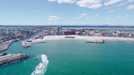 Aerial-dolly-towards-Palavas-Les-Flots-with-jetskis-heading-into-the-harbor