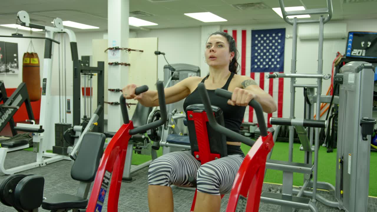 Female athlete training at exerciser in health club