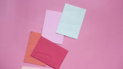 colorful envelopes on pink background