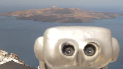 view of the santorini caldera, tracking past a pair of public binoculars