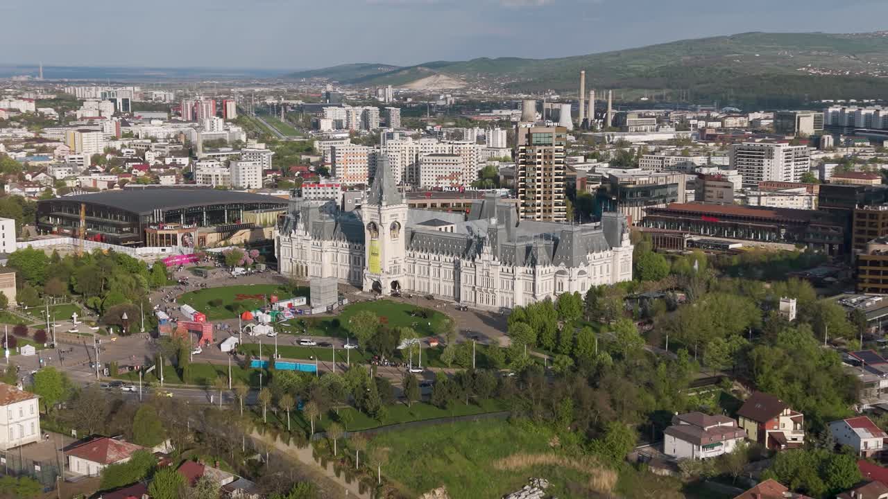 Luftdronepanorama av Kulturpalasset i Iasi, omgitt av bygårder, grønn park og bylandskap i dagslys.