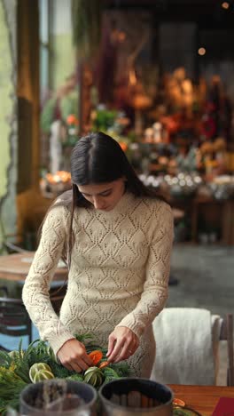 woman creating a christmas wreath in a cafe