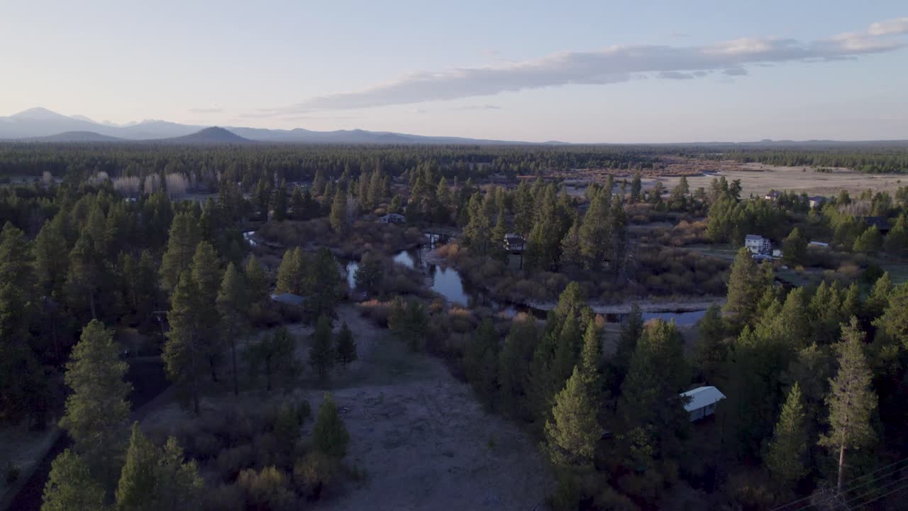 Ripresa aerea con drone in ascesa che si avvicina, focalizzandosi sulle montagne Three Sisters a Bend, Oregon