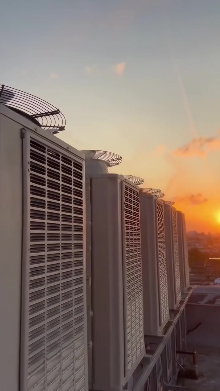 Row of Air Conditioning Units on Rooftop at Sunset