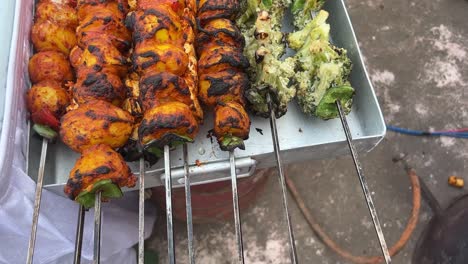 closeup shot of freshly prepared roasted kebabs of potatoes, broccolis, paneer kept on a tray at a stall in kolkata, india during daytime