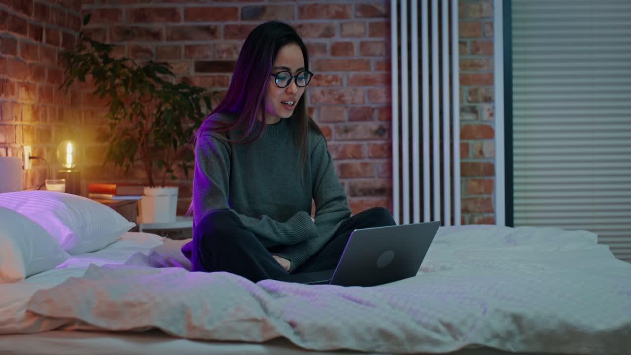 mujer trabajando en la computadora portátil en la cama por la noche