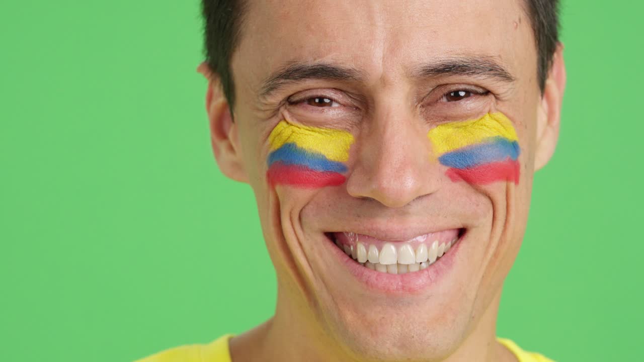 Homem com uma bandeira colombiana pintada no rosto sorrindo