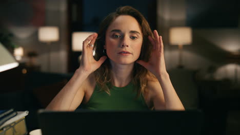 pensive woman watching screen at dark apartments closeup. girl tie hair pencil