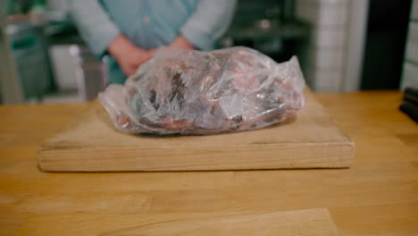 View-of-a-man-placing-a-frozen-steak-loft-in-flank-on-the-table