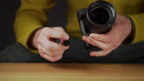 A-caucasian-man-cleaning-the-camera-lens,-removing-dust-and-showing-thumbs-up-gesture