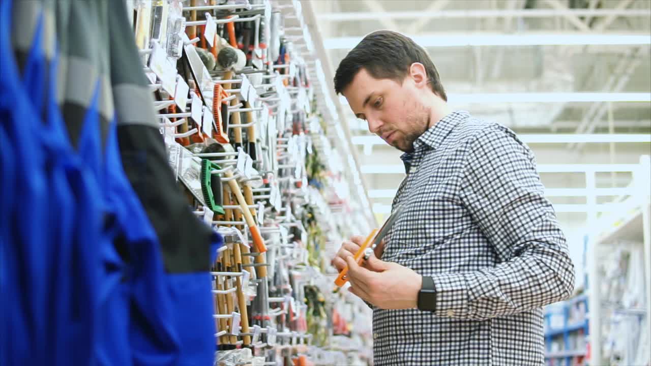 Uomo che guarda gli attrezzi in una ferramenta