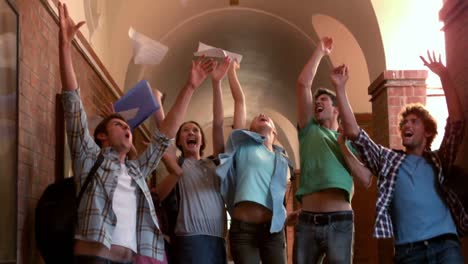 happy students jumping in the air in a hallway