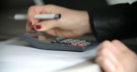 Geschäftsfrau-Mit-Taschenrechner-Im-Büro