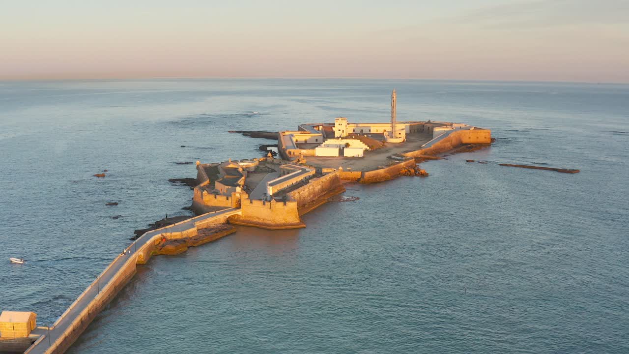 vista aérea de una histórica fortaleza costera y un faro al amanecer o al atardecer