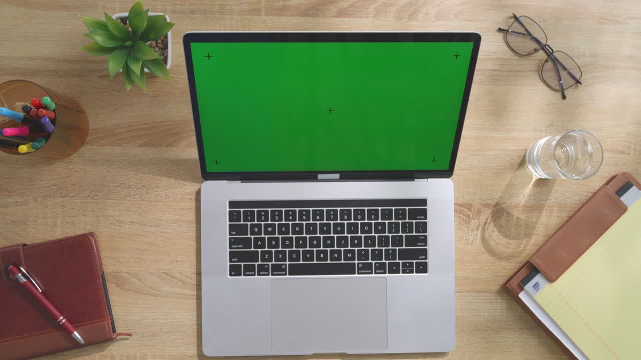 portátil en un escritorio de madera con pantalla verde