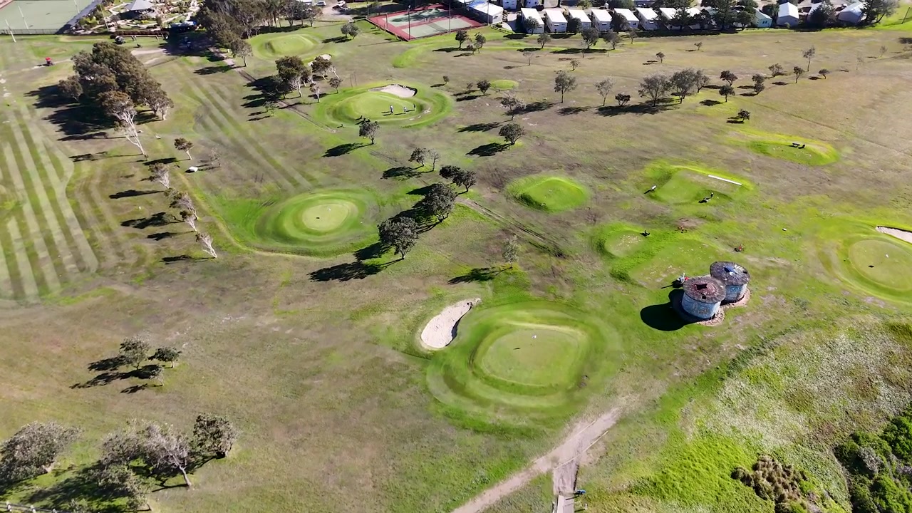 Ripresa aerea con drone di un campo da golf verde vicino a scogliere costiere in Australia
