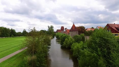 arial view over the river on the right is the city wall and the old town on the left the park and green meadow