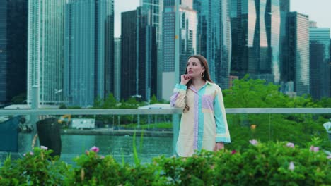 beautiful-caucasian-in-a-solving-problem-position,-Daylight,-outside-in-chicago-with-skyscrapers-in-background-and-green-bushes-in-foregrround