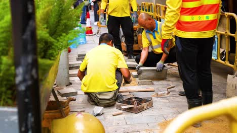 trabajadores que reparan el pavimento en la ciudad de hong kong