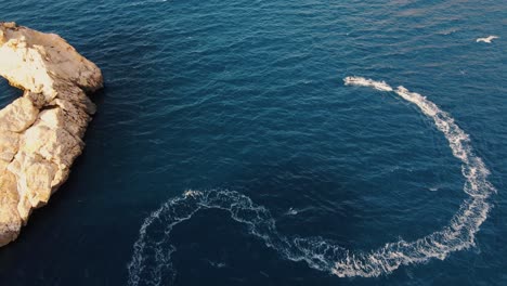 Aerial-view-of-an-electric-surfboard-going-fast-and-leaving-behind-a-large-wake-in-Spain's-sea