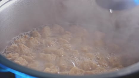 vista de cerca de cocinar y remover trozos de soja