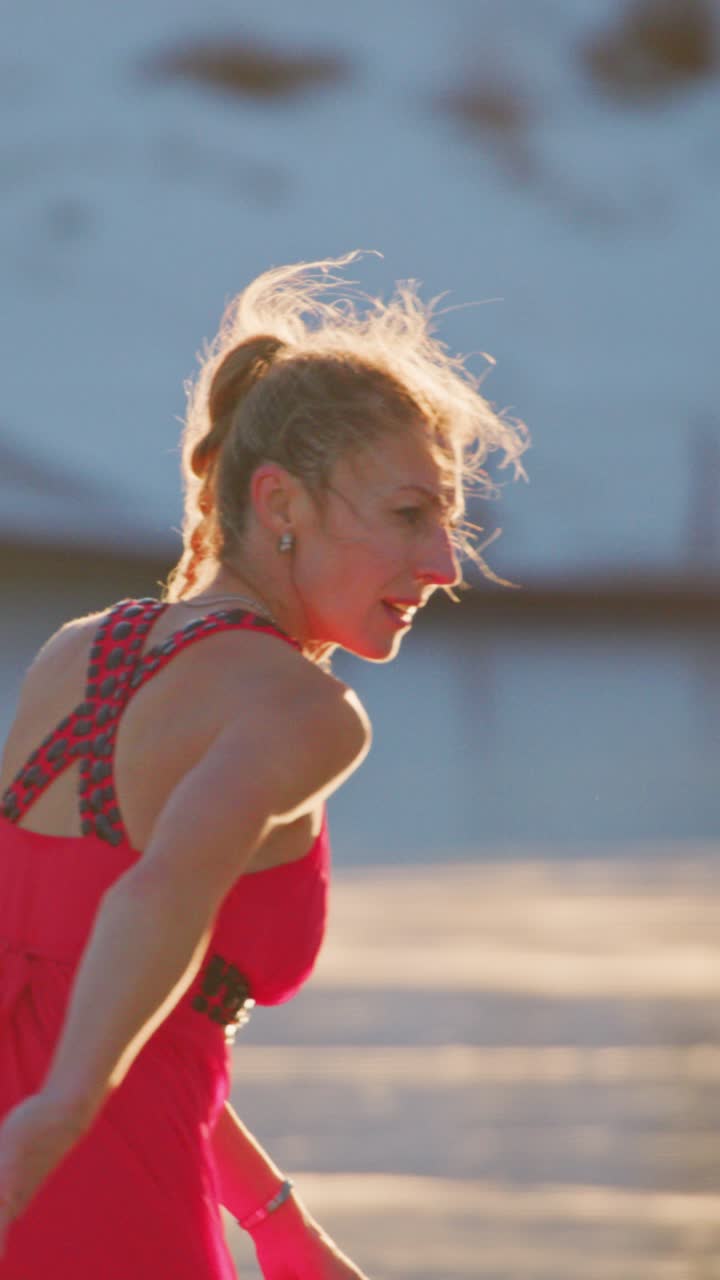 A graceful young skater glides effortlessly across a glistening ice surface in a vibrant red dress, showcasing elegance and skill against a stunning winter landscape capturing the joy of winter sports