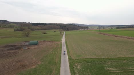 Approaching-motorbike-rider-viewed-from-above-in-the-European-countryside-during-early-spring