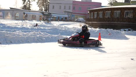 niño en go-kart en una pista nevada