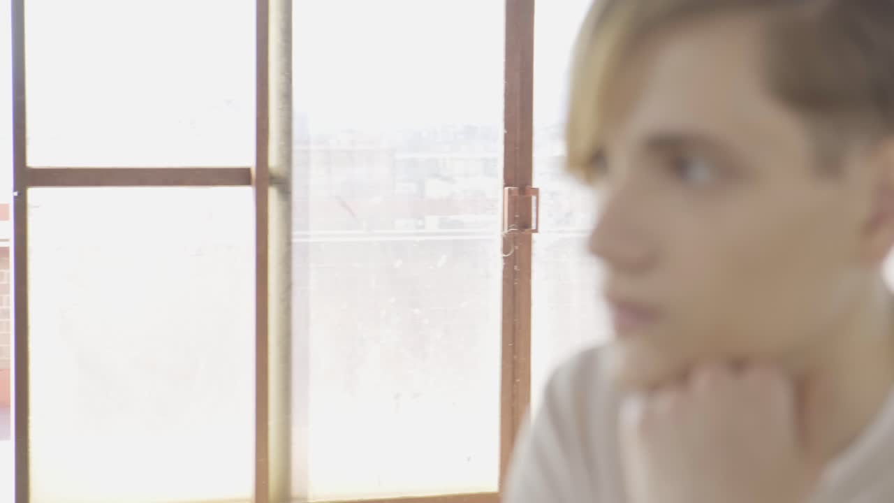 홀 에서 의자 에 앉아 있는 젊은 트렌디 한 남자