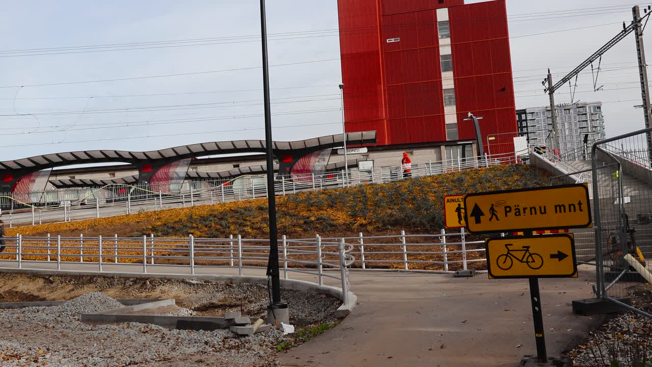 Person walking and biking near a modern train station in Tallinn, Estonia
