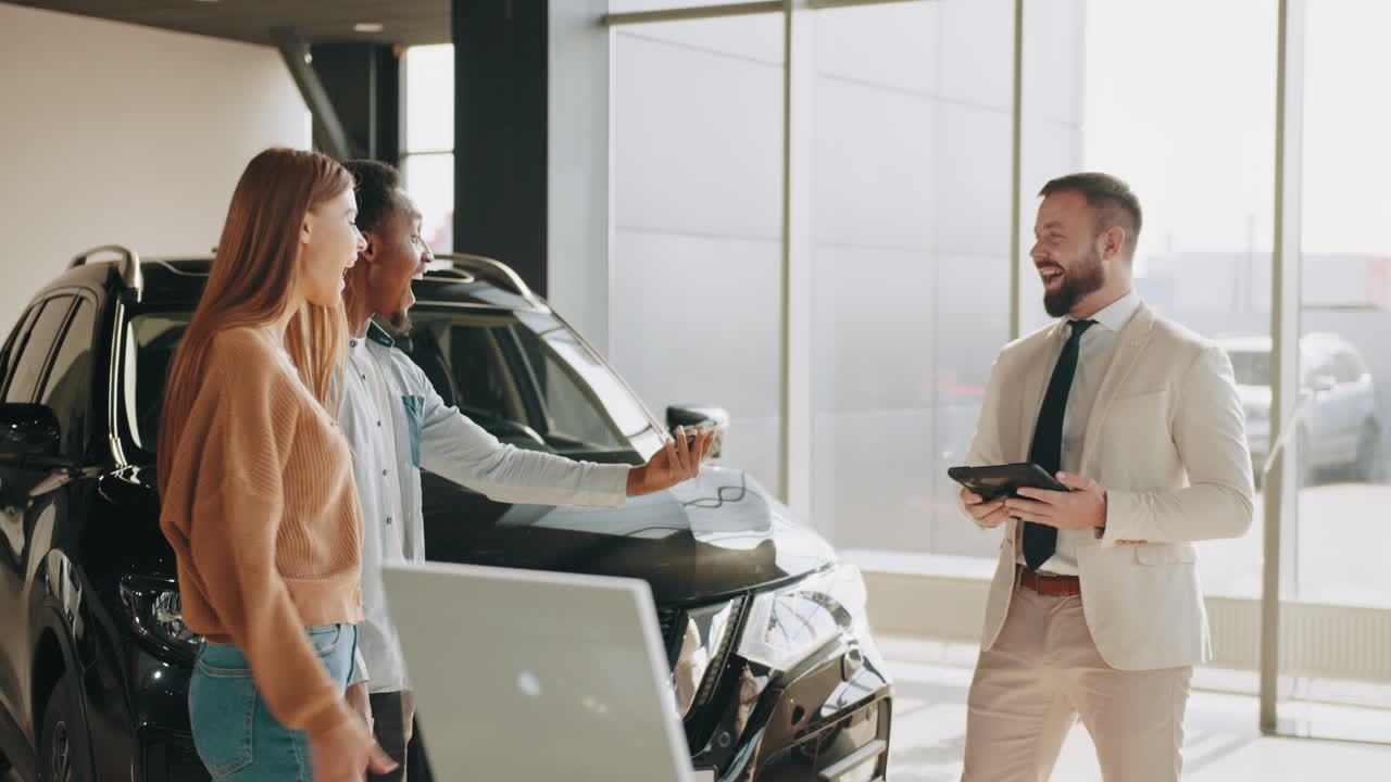 clientes felices celebrando la compra de un coche nuevo en el concesionario