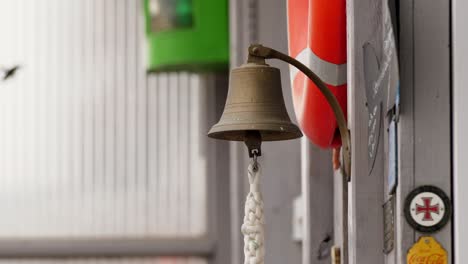 brass bell hangs from the bow of a ship