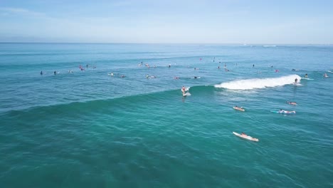 surfers ripping waves at waikiki beach honolulu hawaii, aerial dolly back