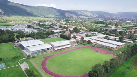 aerial zoom-out drone shot reveals the entirety of a running athletics track