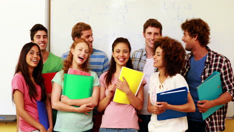 Estudiantes-De-Pie-En-El-Aula-Dando-Pulgares-A-La-Cámara