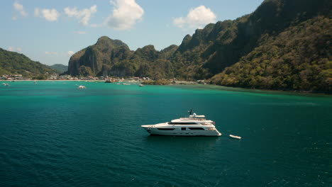 aerial showing big yacht in front of the harbour of el nido, palawan, pilippines