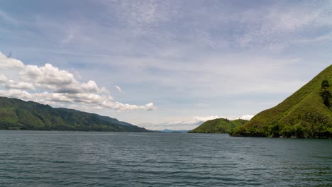 serene lake landscape with lush green mountains under a cloudy sky